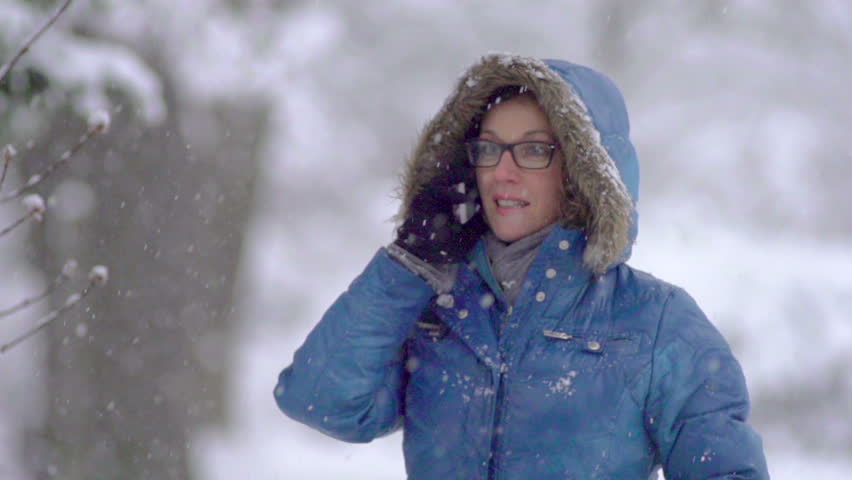 Funny Slow Motion Of Young Woman Talking On The Phone. Snow Falls On Her Head