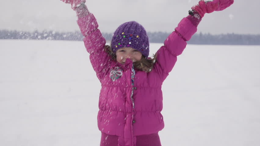 Slow Motion Of Cute Girl Throwing Snow Up In The Air And Smiling At Camera