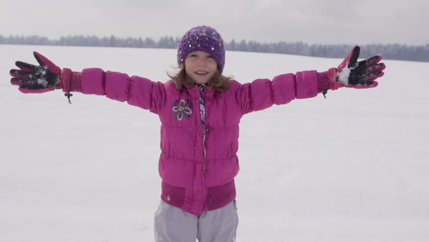 Slow Motion Shot Of A Girl In Pink Parka Throwing Herself Down Into Fresh Snow