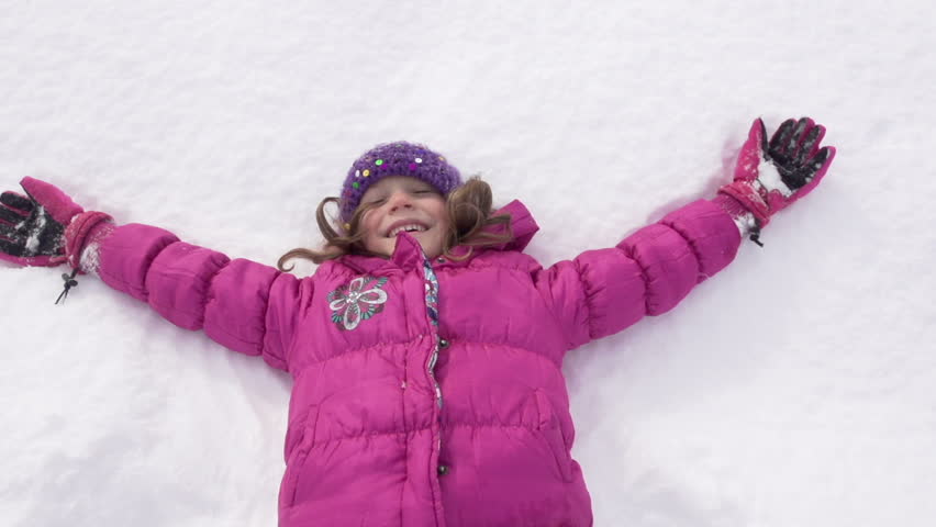 Slow Motion Of A Cute Girl In Pink Parka Happily Lying In Fresh Snow