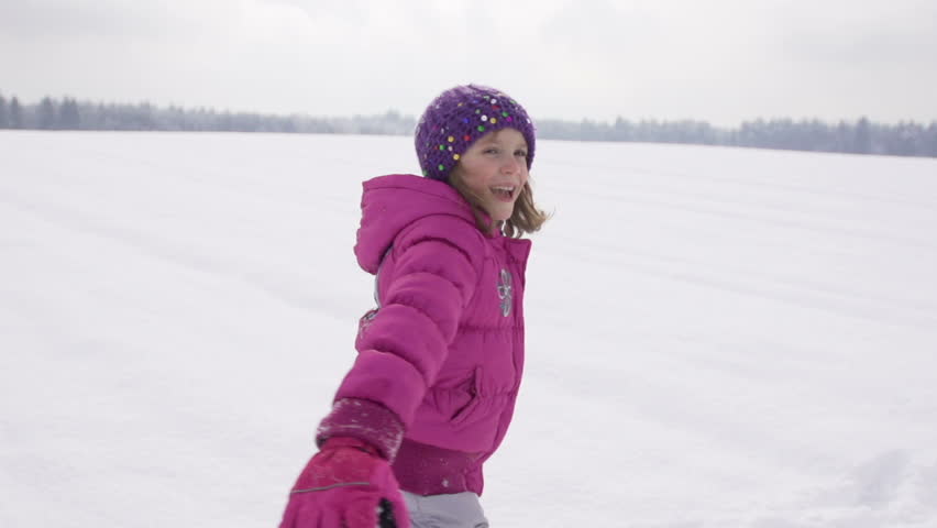 Slow Motion Of A Cute Girl Spinning And Then Throwing Herself In Fresh Snow On A