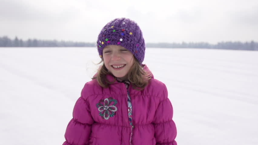 Slow Motion Of A Cute Girl Blowing Her Nose Outdoors On Snow Covered Field