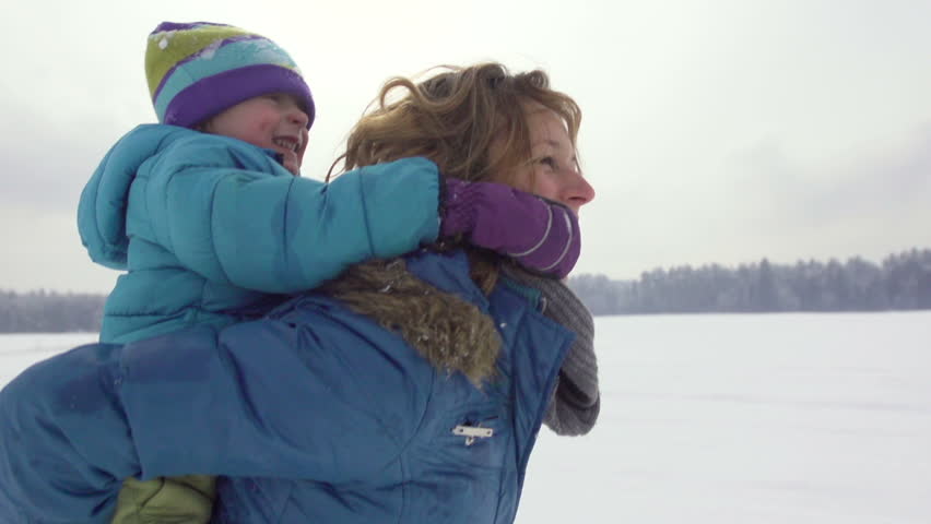 Beautiful Slow Motion Of Mother Carrying Her Three-Year-Old Son Piggyback And