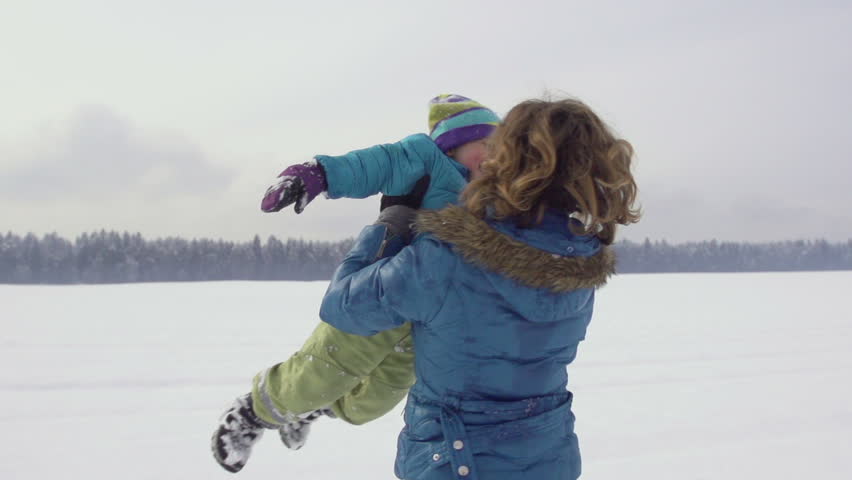 Spectacular Slow Motion Of Mother Spinning Her Little Boy On A Snow Covered