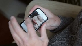 Man video chatting on smartphone with senior woman