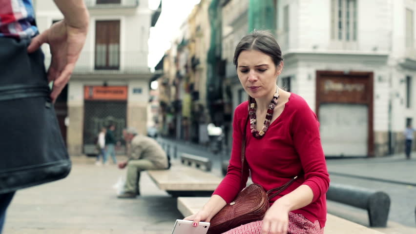 Young attractive couple sitting on bench, kissing and talking
