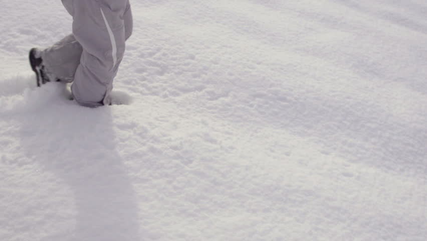 Slow Motion Of A Girl's Legs Trudging Through Fresh Snow On A Winter Day