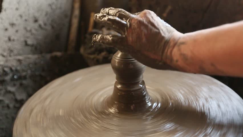 Close-up of hands working clay on potter's wheel. (HD)