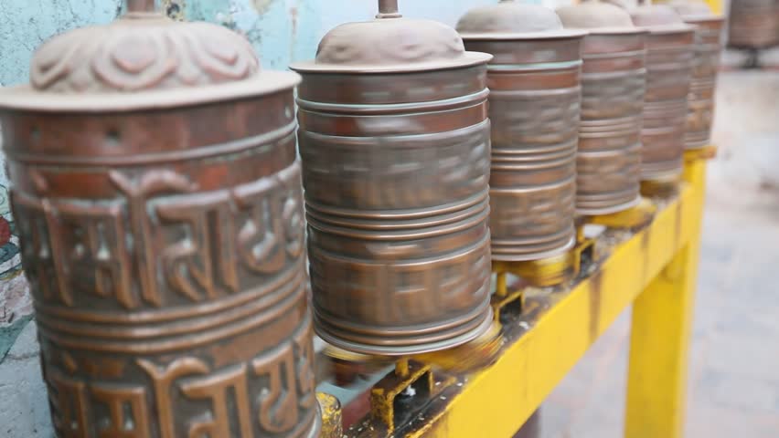 Spinning Tibetan Buddhist prayer wheels at Boudhanath stupa in Kathmandu, Nepal 
