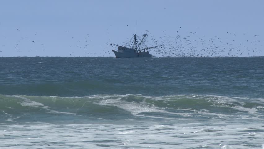 A commercial fishing boat on the horizon in the distance.  In 4K UltraHD.