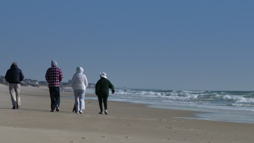 People walk along the beach in the winter.  In 4K UltraHD.