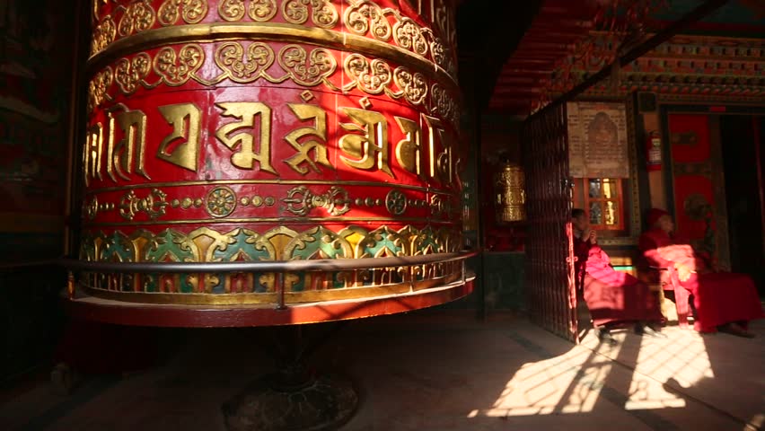 KATHMANDU, NEPAL - DEC 8: Unidentified monks touches spinning Big Tibetan