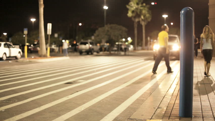 People walking at night at a shopping plaza
