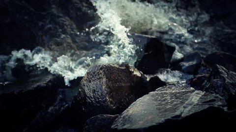 Water splashing against rocks (super slow motion)