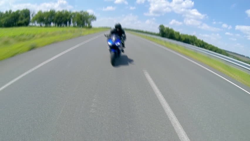 Man sitting on the motorcycle and moving on the road.