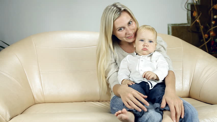 Mother with son on sofa watch TV      