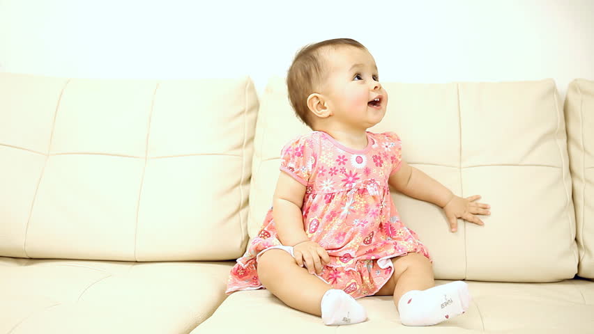 Smiling baby sitting on the sofa