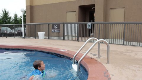 Boy climbing out of swimming pool