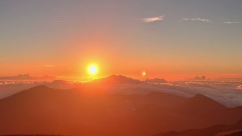 Brilliant summit dawn above flowing cloud waves, red sun disk time lapse in HDR 