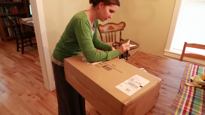 A woman opens a package that she received in the mail