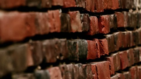 Side way image of the brick wall being shown. The brick wall is mostly red brown in color.