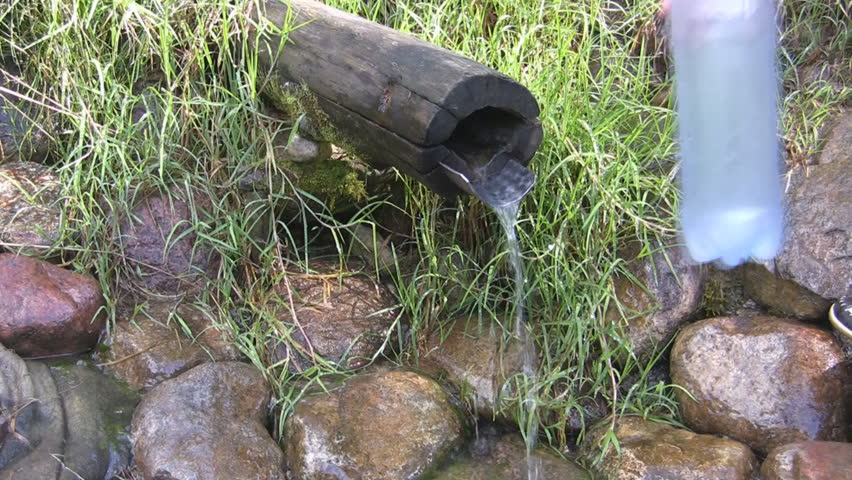 Bottle fulling mineral water in the source