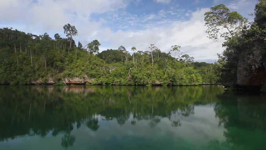 High, limestone islands, covered by tropical vegetation, protect a calm bay in