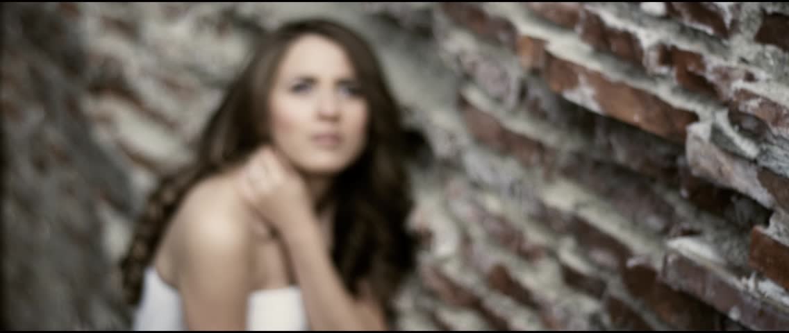 Beautiful bride in her wedding dress next to a wall