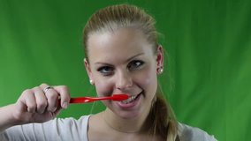 Beautiful woman brushing her teeth and smiling Healthy lifestyle - regular hygiene. Video footage to chroma-key background.