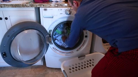 A father does the families laundry in his home