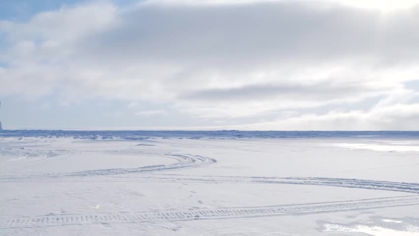 Arctic expedition camp and helicopter on frozen tundra. (Pan Left)
