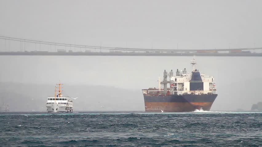Sea Transportation. Cargo ship sailing out the harbor in winter. 