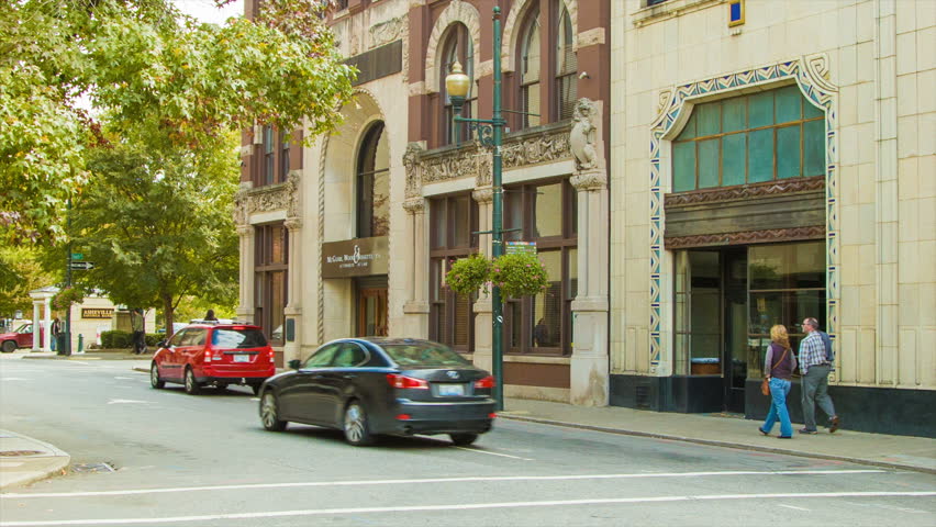 Downtown Asheville, NC Scene with Vehicle and Pedestrian Traffic on a Sunny Day Among Historical Buildings.