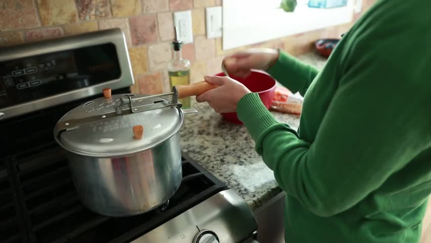 A woman making popcorn in her home for a snack