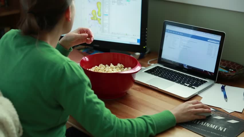 A working mother in her home office snacking on popcorn