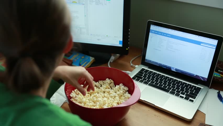 A working mother in her home office snacking on popcorn