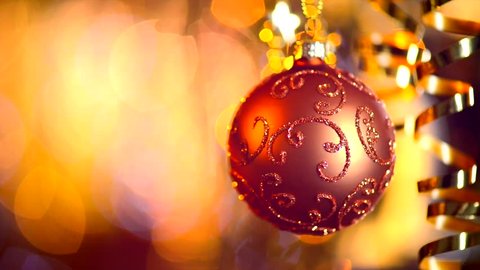 Christmas and New Year Decoration. Hanging Bauble close up. Abstract Blurred Bokeh Holiday Background. Blinking Garland. Christmas Tree Lights Twinkling.