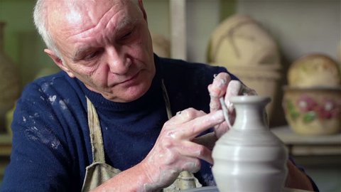 Experienced potter creating a beautiful clay vase using professional tools