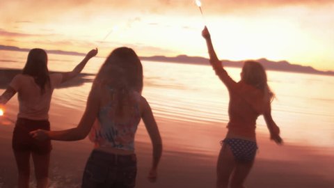 Teenage Girls With Sparklers On The Beach At Sunset