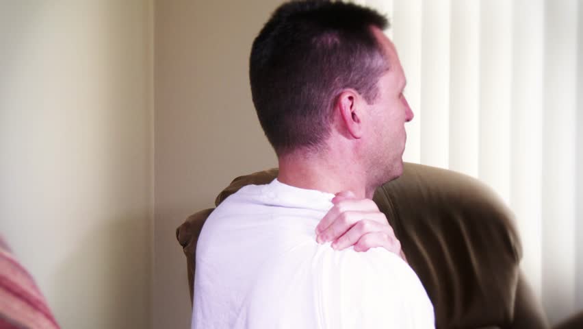 A man rubs his aching shoulder.