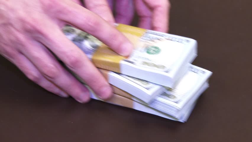 A pile of $40,000 in new $100 bills gets slid across the desk. In 4K UltraHD.