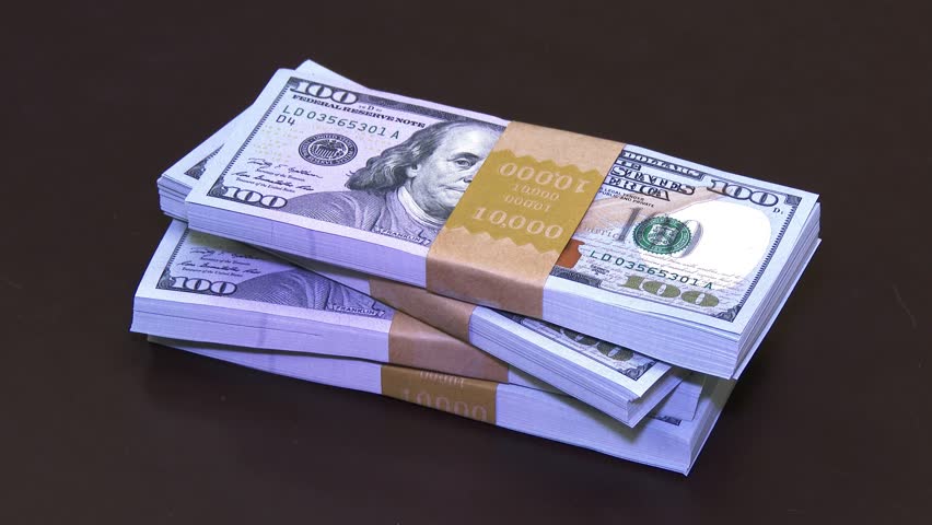 A pile of $40,000 in new $100 bills gets stacked up on a desk. In 4K UltraHD.