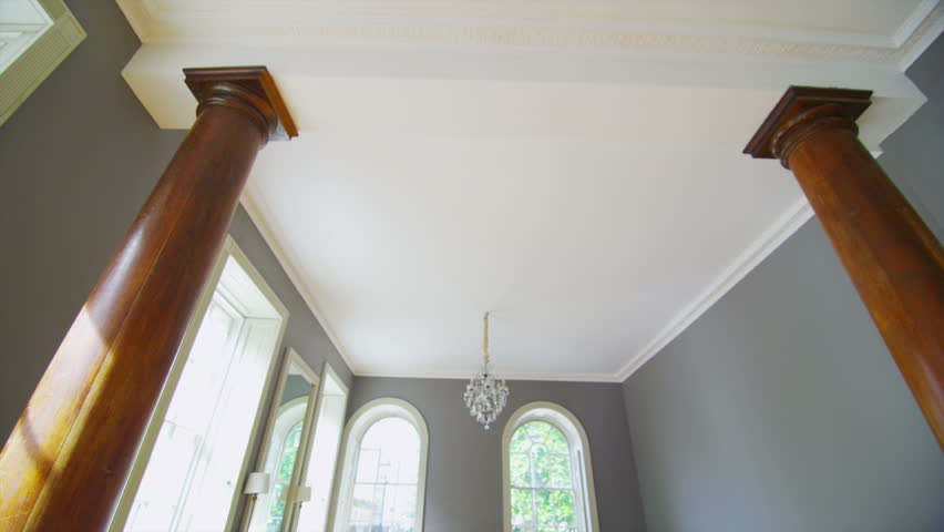 View of elegant living area in a stylish, classically designed home with large windows and lots of natural light. No people.