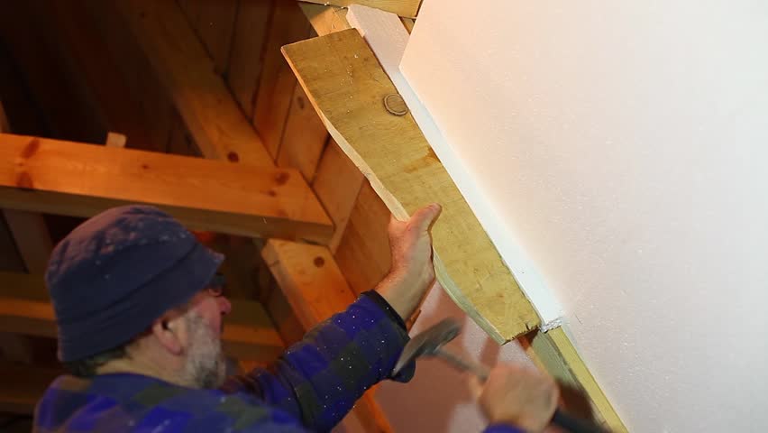 A repairman fitting in the styrofoam insulation | Shutterstock HD Video #5243030