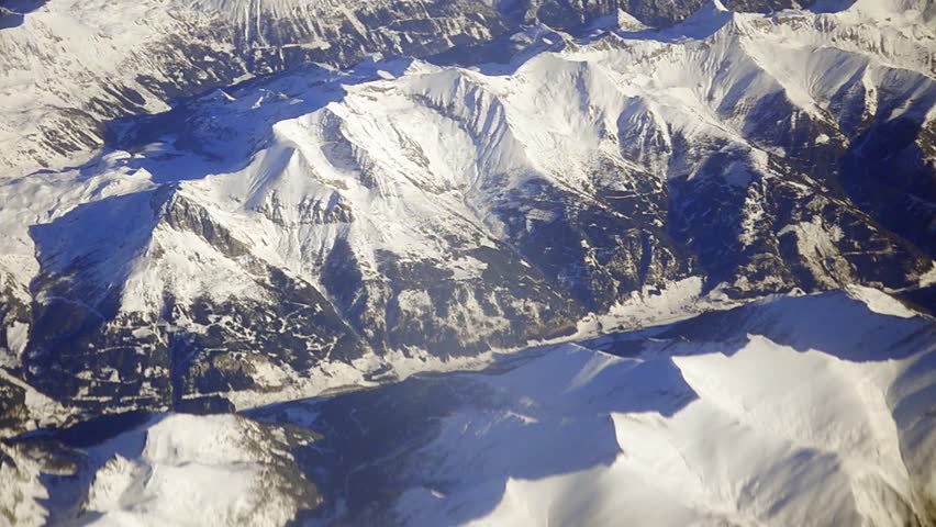 Aerial following jagged ridge into valley in Nepal.