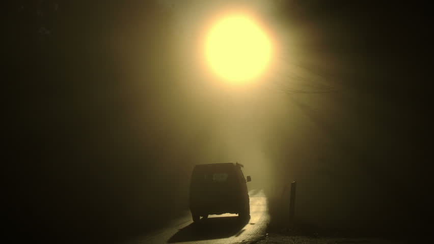 Cars driving into fog directly on sun