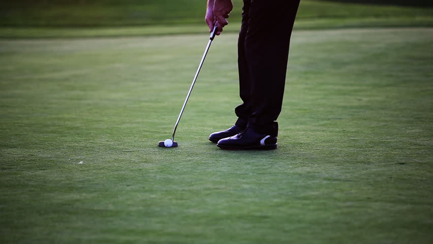 Golf player taking his putt on beautiful golf course