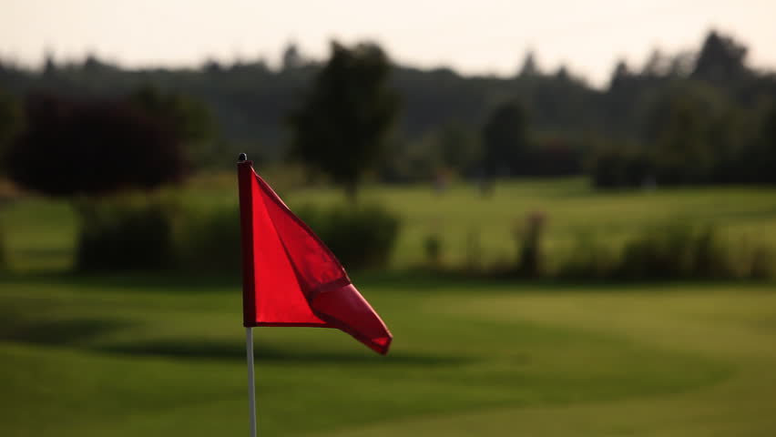 Close up of a red flag on a golf course