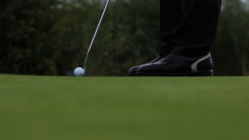 Golf player taking his putt on beautiful golf course