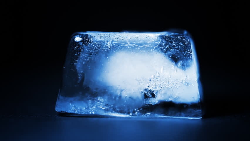 Death of cold blue ice cube in time lapse
